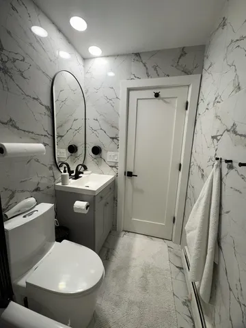 a bathroom with a toilet sink and mirror
