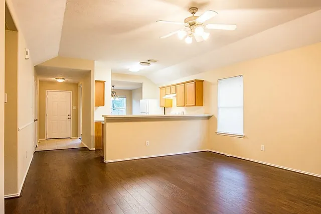 a view of a kitchen with wooden floor and a ceiling fan