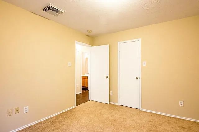 a view of a big room with windows and chandelier fan