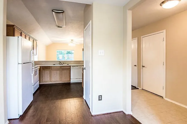 a view of a kitchen with a sink and a refrigerator