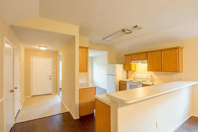 a view of a kitchen with kitchen island a sink appliances