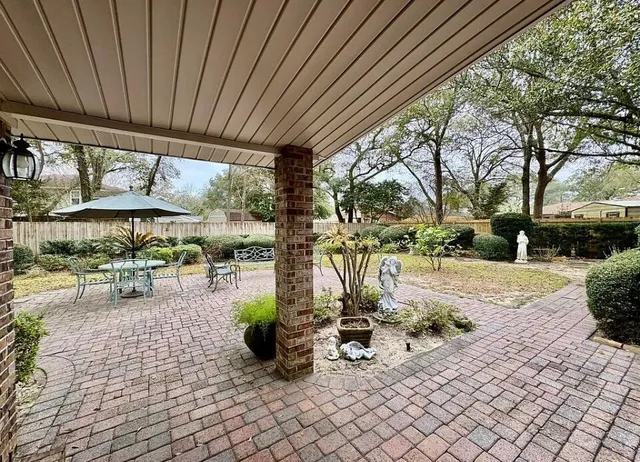 a view of a patio with a table and chairs under an umbrella