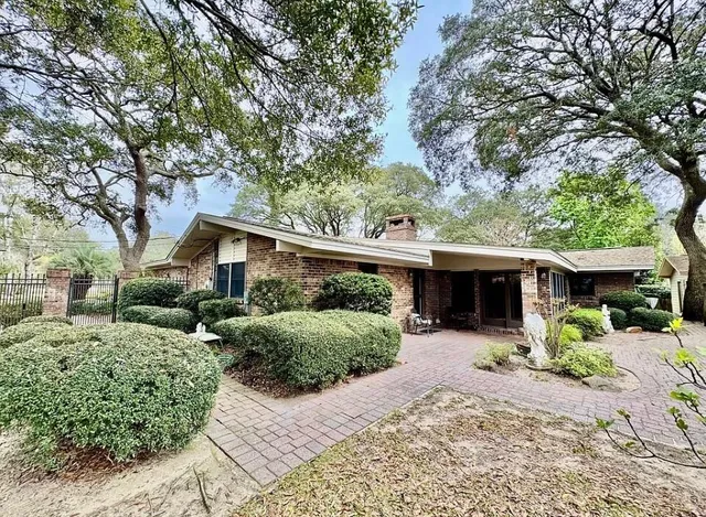 a front view of a house with a yard and potted plants