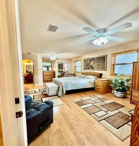 a bedroom with furniture and a chandelier fan