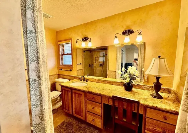 a bathroom with a granite countertop sink and a mirror