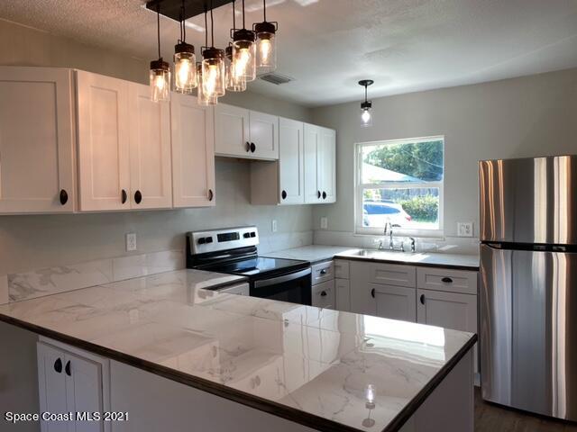 5401 Flint Road Cocoa, FL 32927 - Photo 3 of 13 a kitchen with granite countertop a sink a center island stainless steel appliances and cabinets