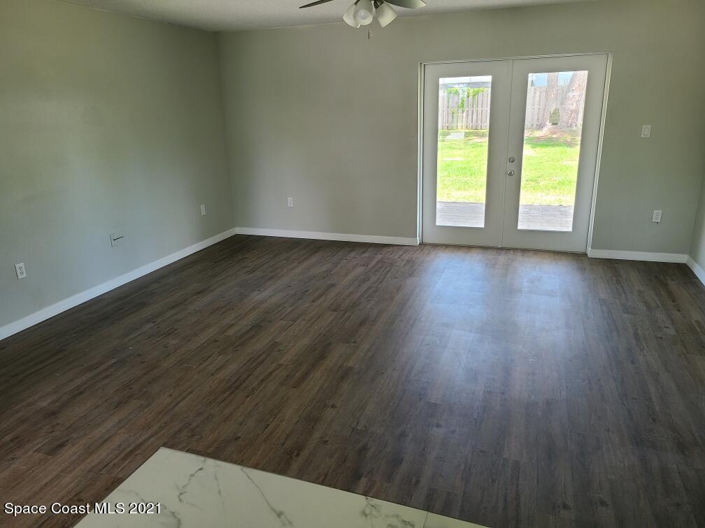 5401 Flint Road Cocoa, FL 32927 - Photo 6 of 13 a view of an empty room with wooden floor and a window