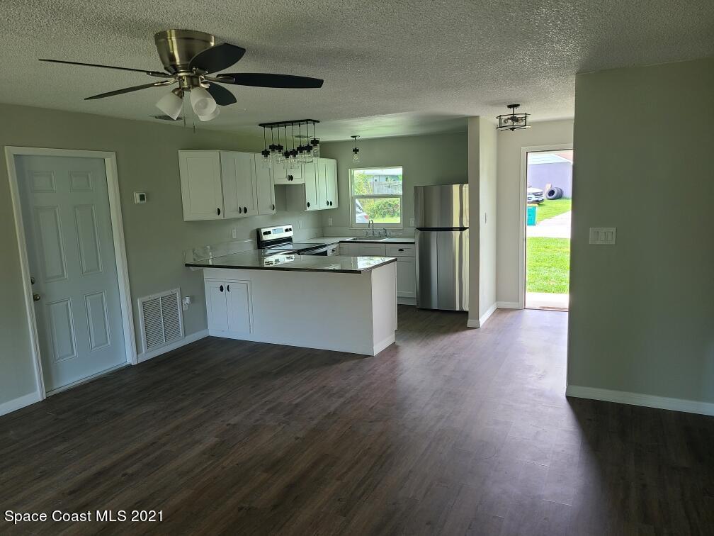 5401 Flint Road Cocoa, FL 32927 - Photo 7 of 13 a view of a kitchen with a sink and a refrigerator