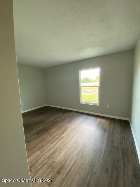 5401 Flint Road Cocoa, FL 32927 - Photo 10 of 13 an empty room with wooden floor and windows