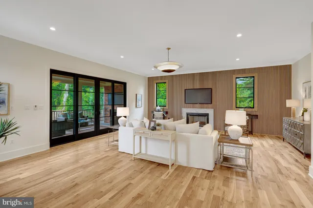 a living room with furniture tv and large windows