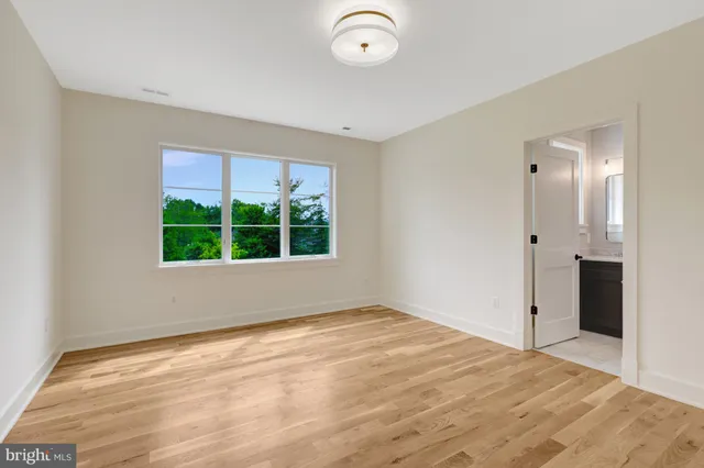 a view of a hallway with wooden floor and windows