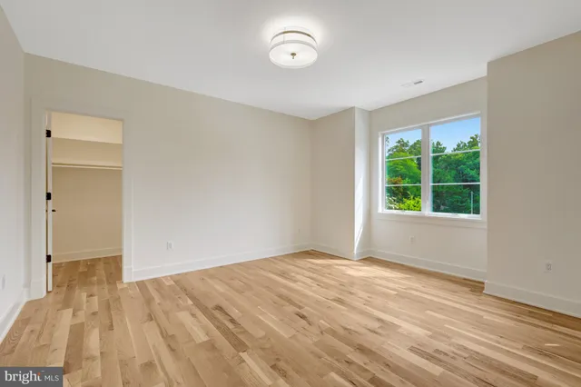 an empty room with wooden floor and mirror