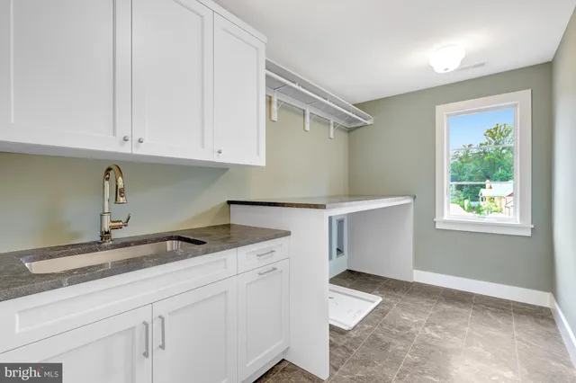 a view of empty room with wooden floor and kitchen