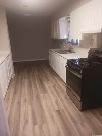 a kitchen with a stove and white cabinets