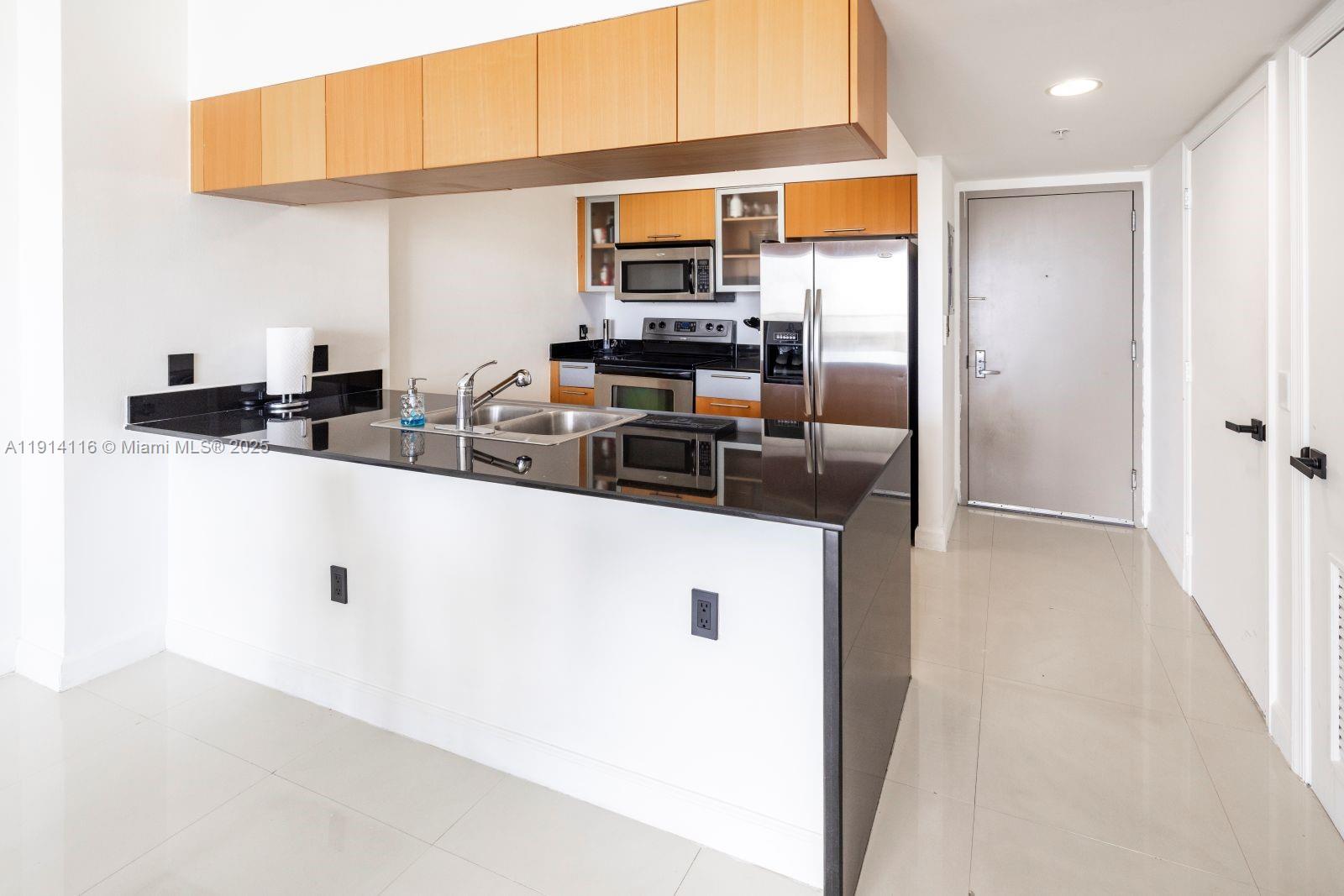 1750 North Bayshore Drive, Unit 4312 Miami, FL 33132 - Photo 4 of 10 a kitchen with stainless steel appliances a sink dishwasher and refrigerator