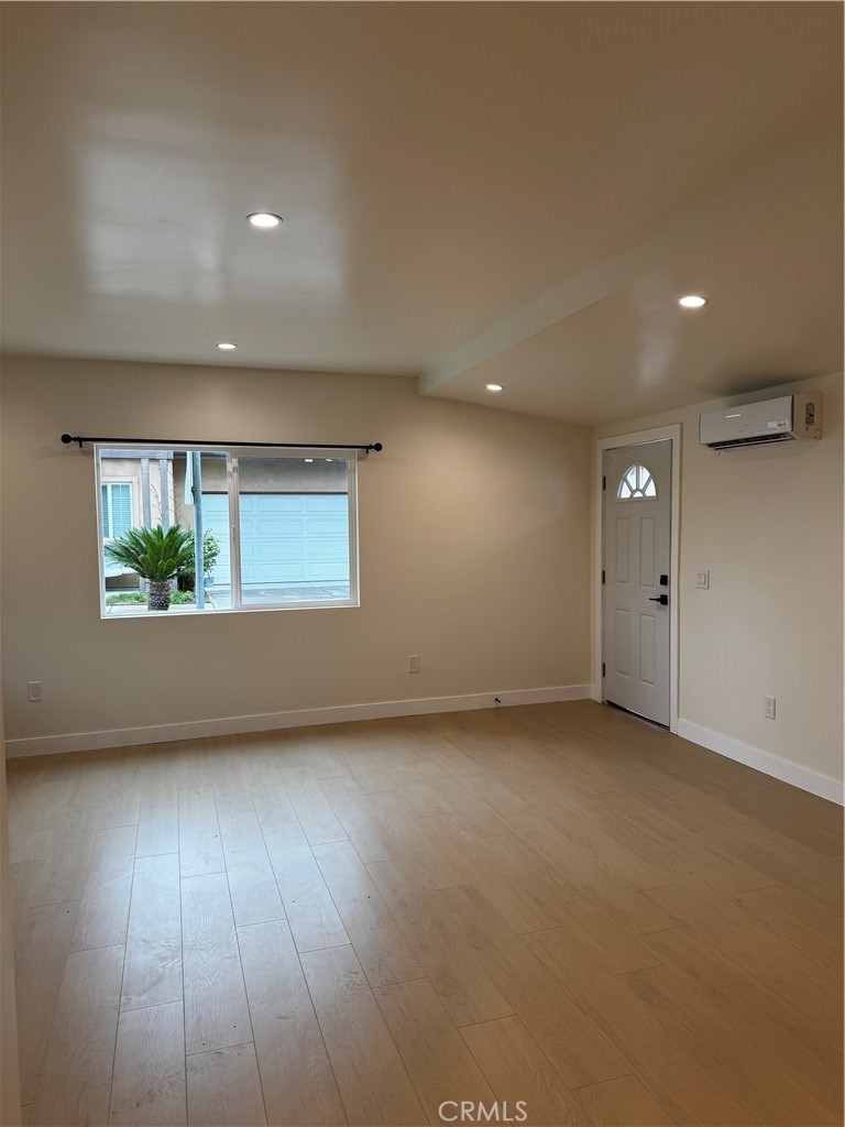 8109 Cole Street, Unit B Downey, CA 90242 - Photo 8 of 11 an empty room with wooden floor and windows