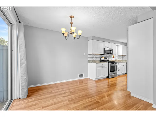 a view of empty room with wooden floor and fireplace