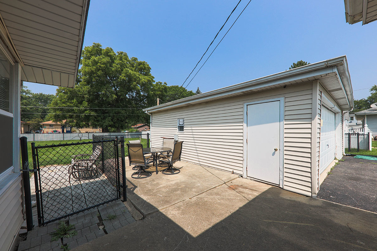 815 Bronk Road Joliet, IL 60404 - Photo 20 of 23 a view of a patio with a table and chairs and wooden fence