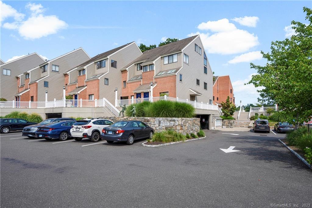 9 River Road, Unit 403 Greenwich, CT 06807 - Photo 1 of 1 a car parked in front of a white house