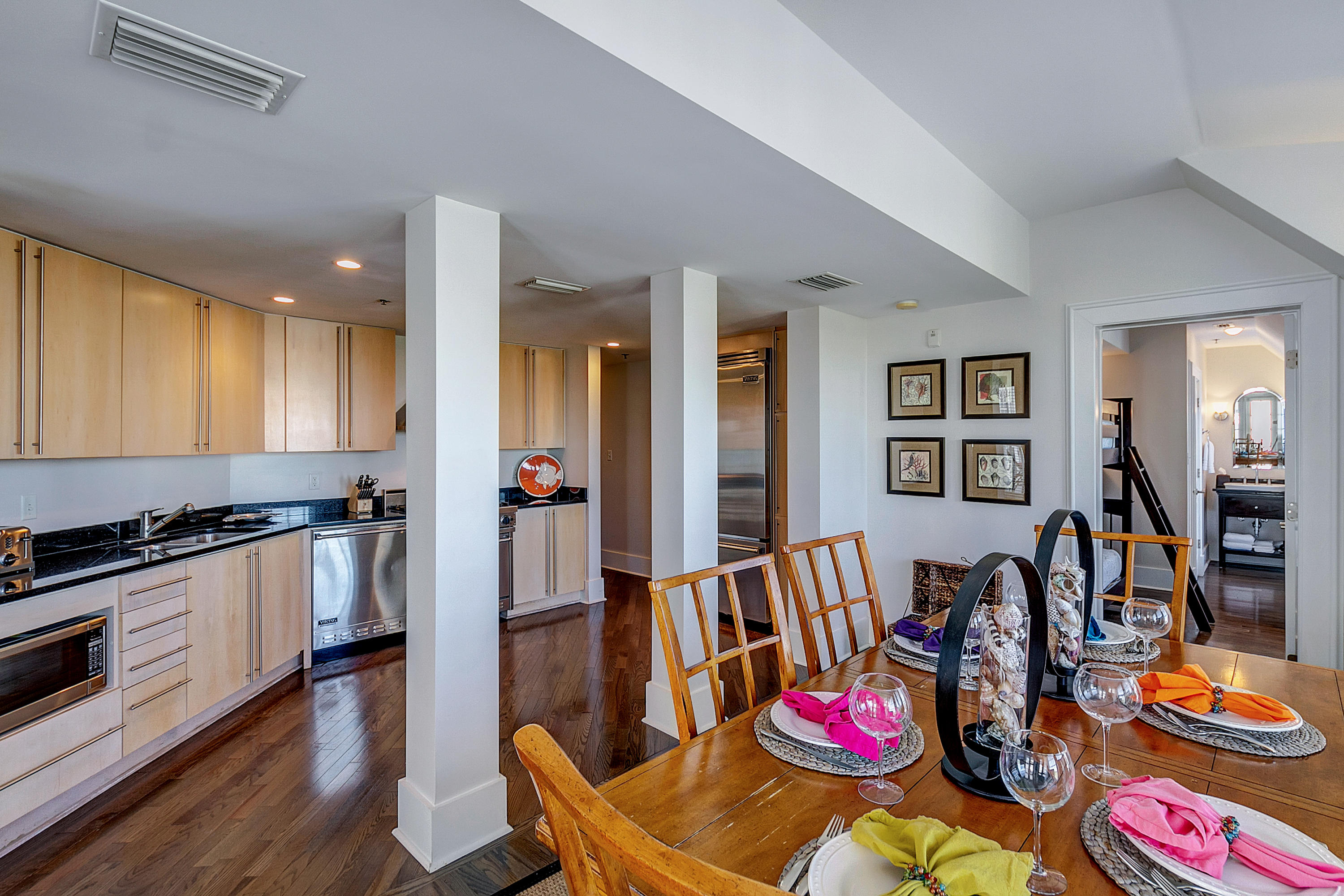 5 Main Street, Unit 1F Rosemary Beach, FL 32461 - Photo 8 of 24 a kitchen with stainless steel appliances wooden floor dining table and chairs