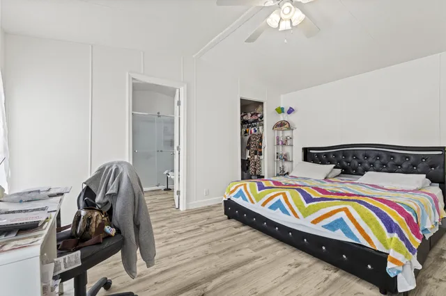 a bedroom with bed and wooden floor