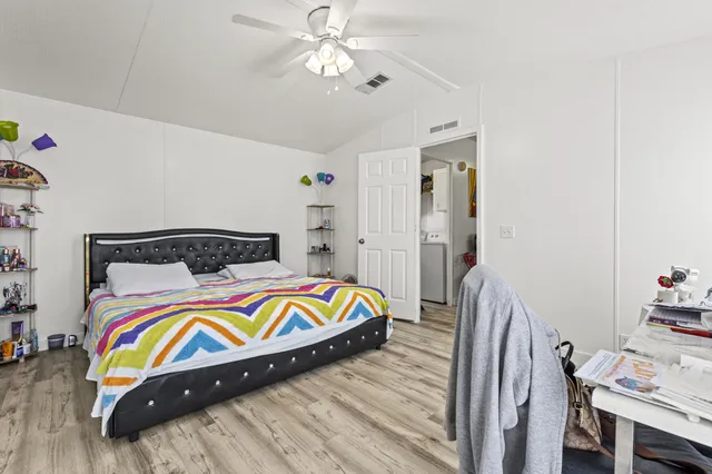 a bedroom with bed and wooden floor