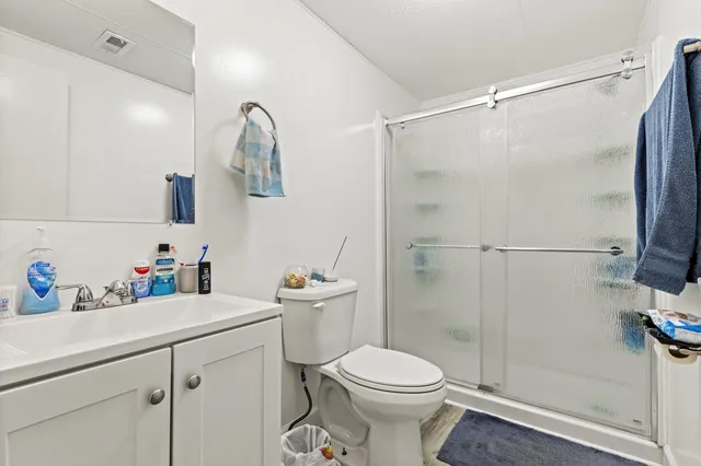 a bathroom with a sink a toilet and shower