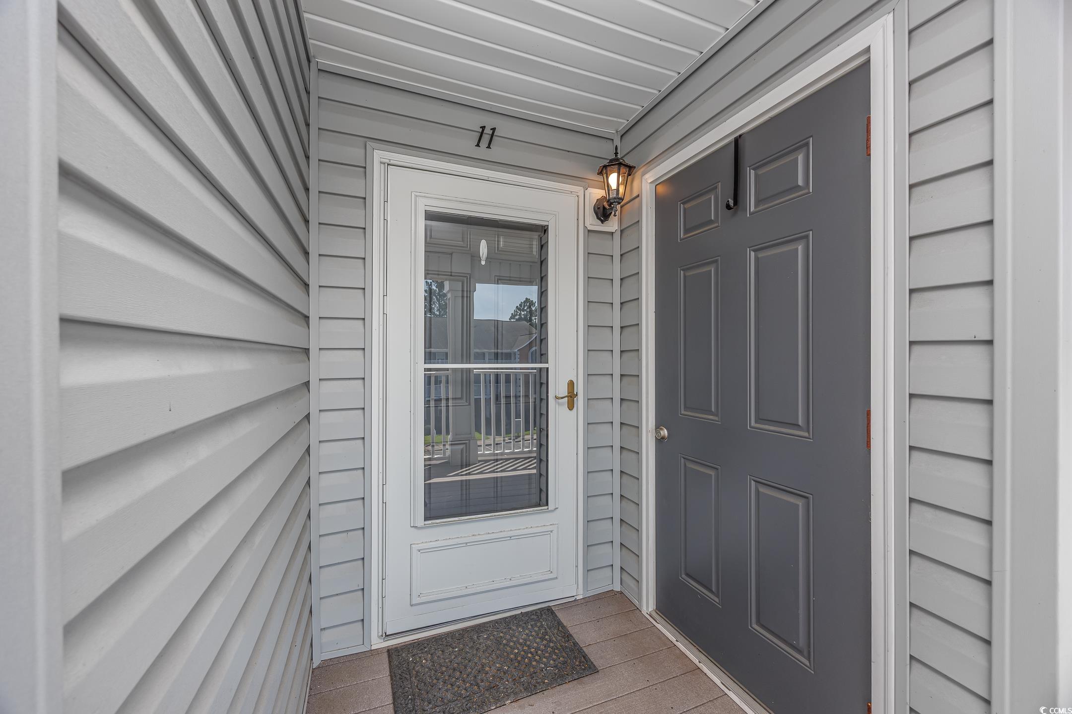 4850 Meadowsweet Drive, Unit 1711 Myrtle Beach, SC 29579 - Photo 34 of 39 Front door featuring hideaway screen. Storage closet to the right.