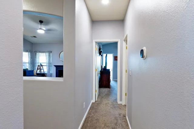 a view of a hallway with wooden floor and staircase
