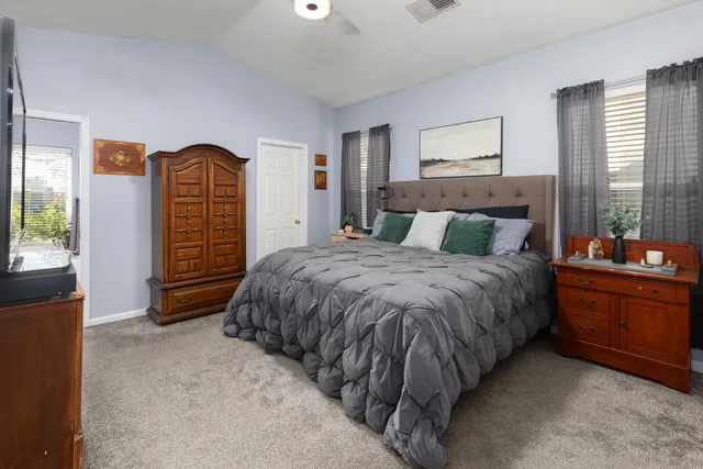 a spacious bedroom with a bed and wooden floor