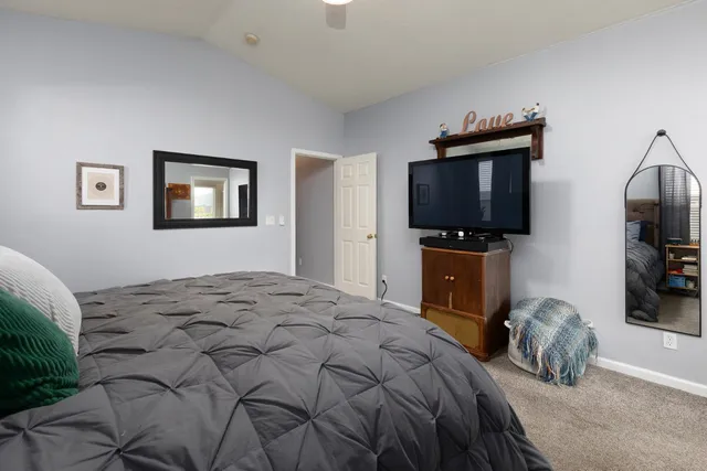 a bedroom with a bed and a flat screen tv