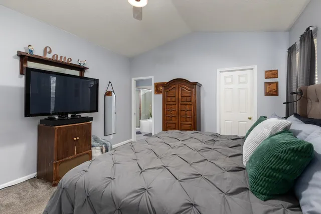 a bedroom with a bed and a flat screen tv