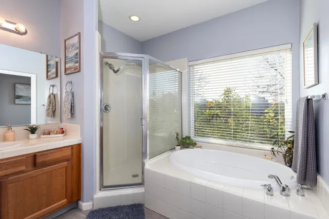 a bathroom with a tub sink and mirror