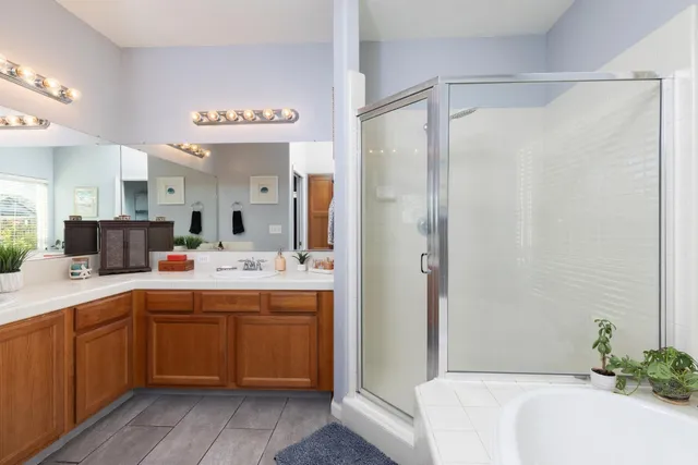 a spacious bathroom with a tub sink shower and mirror
