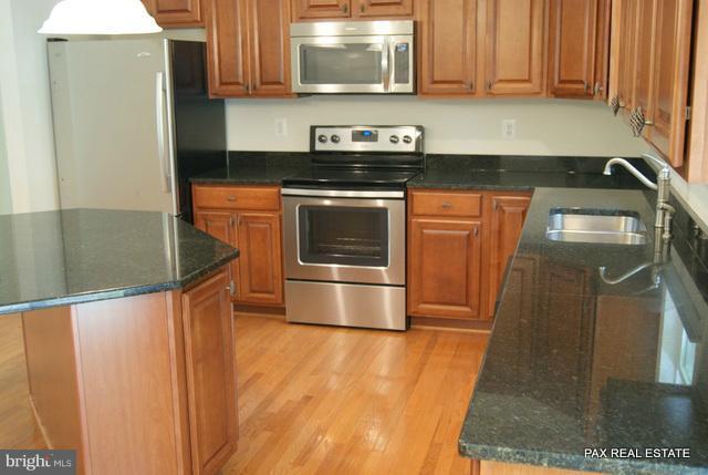 4430 Solomons Island Road Huntingtown, MD 20639 - Photo 5 of 17 a kitchen with granite countertop a stove and a refrigerator