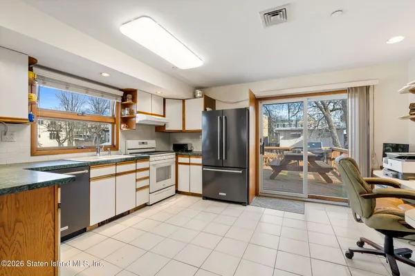 a kitchen with granite countertop a refrigerator and a sink