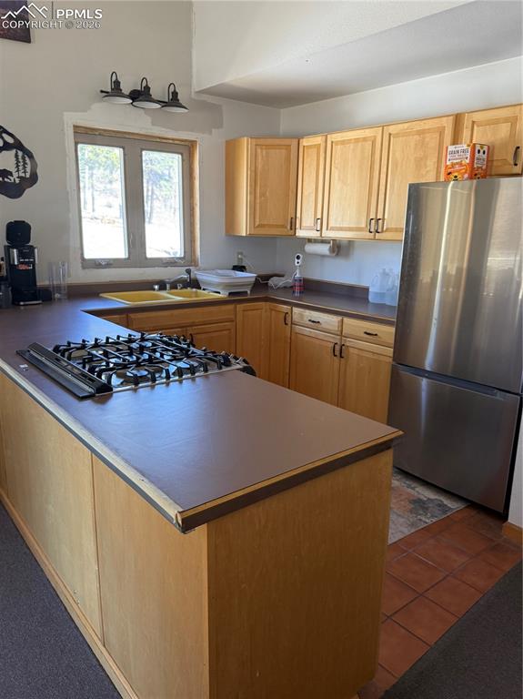 450 Schierl Road Fort Garland, CO 81133 - Photo 24 of 40 a kitchen with stainless steel appliances granite countertop a refrigerator a sink dishwasher a stove a washer and dryer with wooden floor