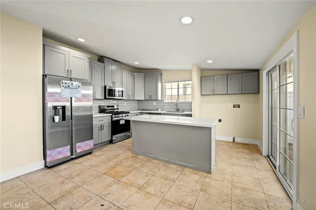 a kitchen with stainless steel appliances granite countertop a refrigerator and a sink