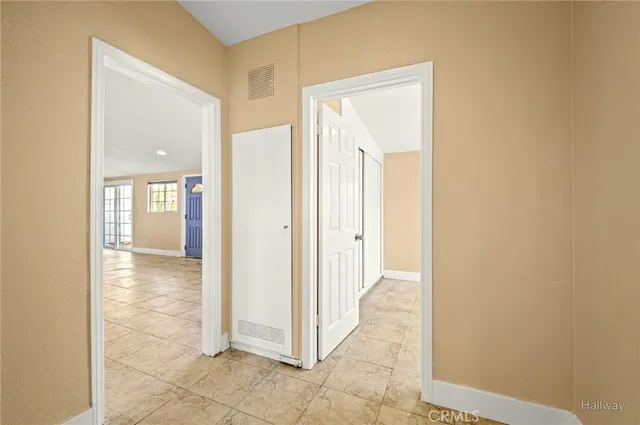 a view of a hallway with wooden floor and a bathroom