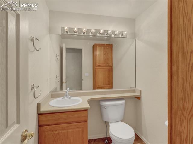 8599 Tibbs Road Peyton, CO 80831 - Photo 26 of 38 Main level 1/2 bath is perfect for guests and features extra storage cabinets