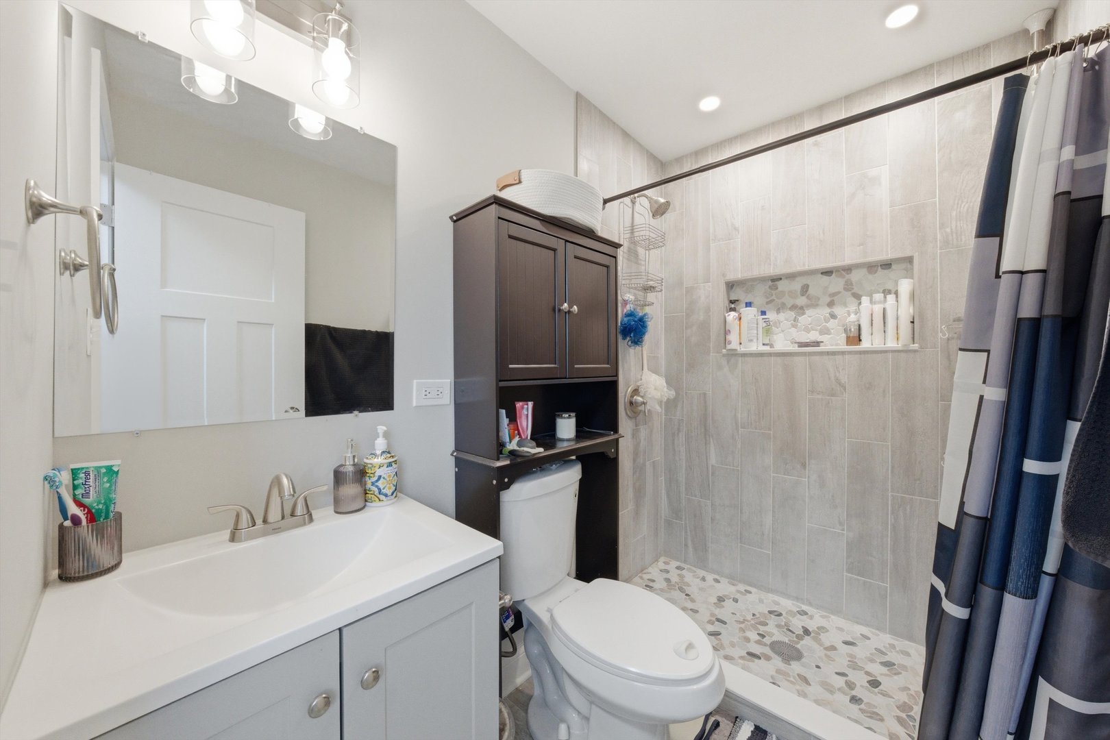 8945 South Corcoran Road Hometown, IL 60456 - Photo 12 of 24 a bathroom with a sink a toilet a shower and a mirror