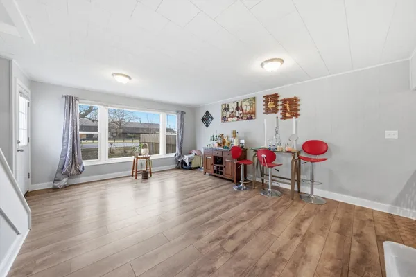 a view of a room with lots of furniture and white walls