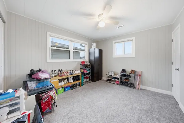 a living room with furniture a baby crib and a window