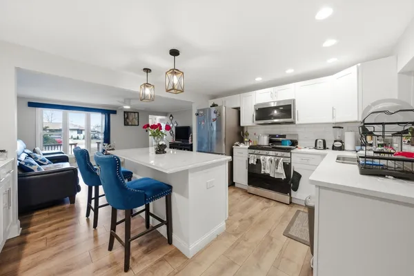 a kitchen with kitchen island a stove a table and chairs in it