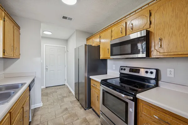 a kitchen with stainless steel appliances granite countertop a stove microwave refrigerator and sink