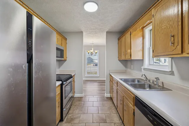 a kitchen with stainless steel appliances granite countertop a sink and a refrigerator