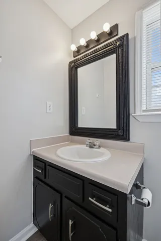 a bathroom with a granite countertop sink a mirror and vanity