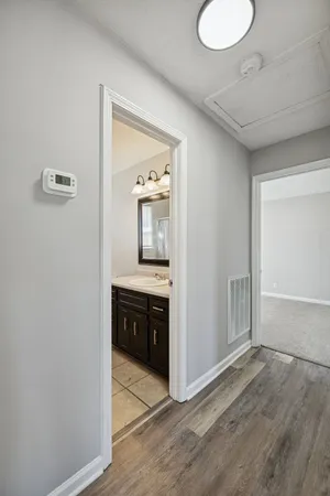 a view of a hallway and an entryway with wooden floor
