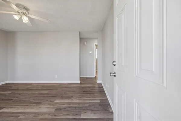 a view of an empty room with wooden floor