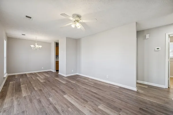 a view of an empty room with wooden floor